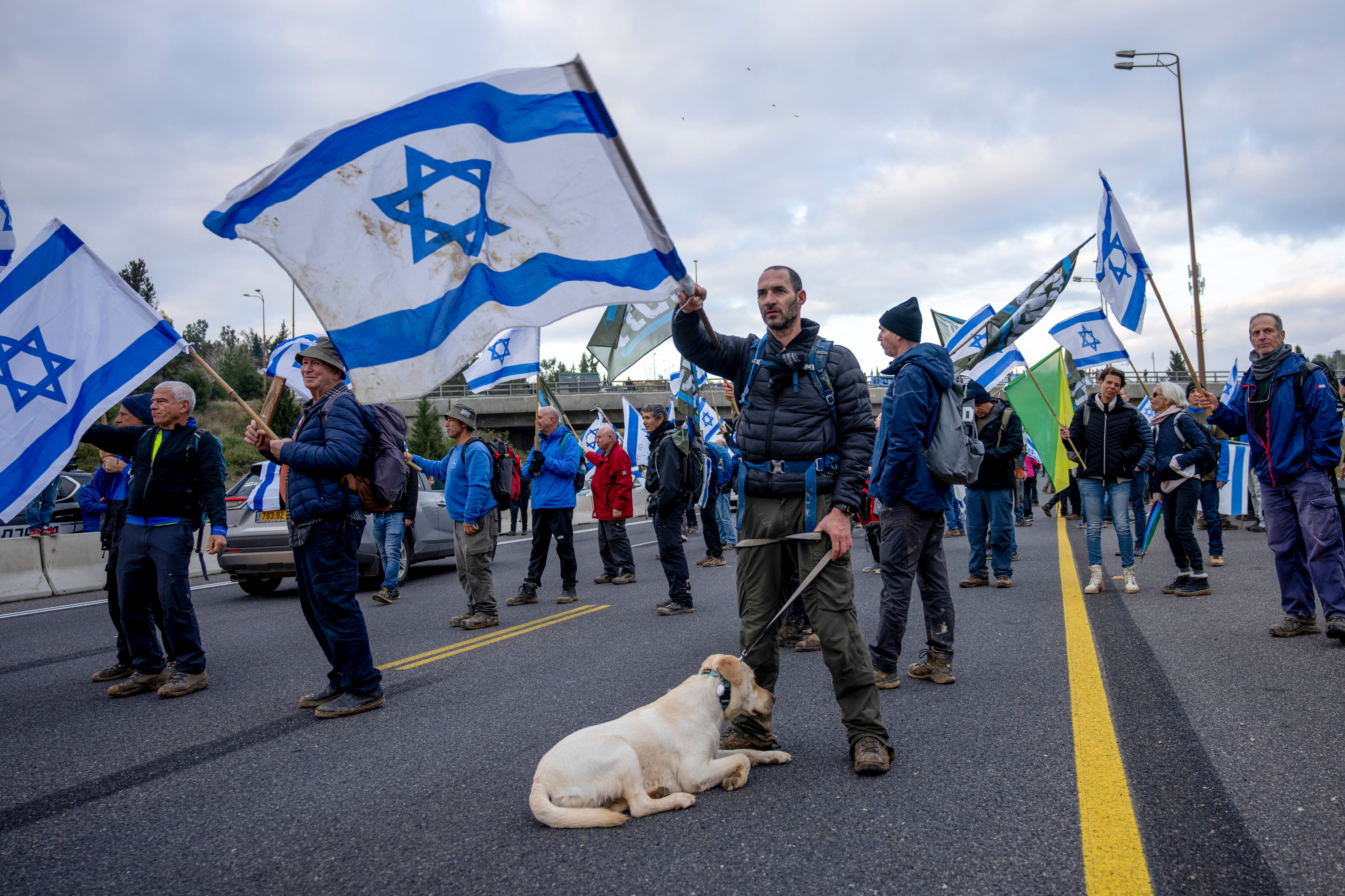 Israeli military reservists protest against the plans by Prime Minister Benjamin Netanyahu's new government to overhaul the judicial system, on a freeway from Tel Aviv to Jerusalem, Thursday, Feb. 9, 2023.