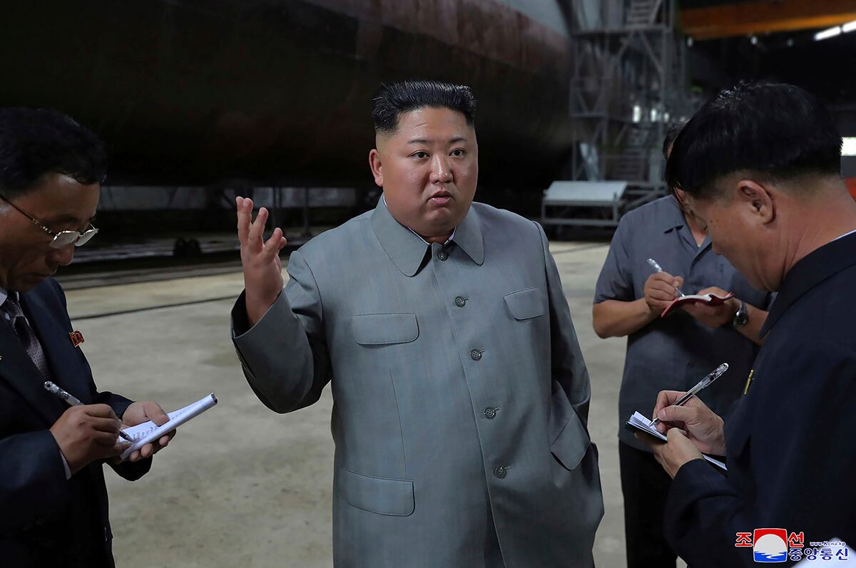 In this undated photo provided on Tuesday, July 23, 2019, North Korean leader Kim Jong Un, center, speaks while inspecting a newly built submarine to be deployed soon, at an unknown location in North Korea.