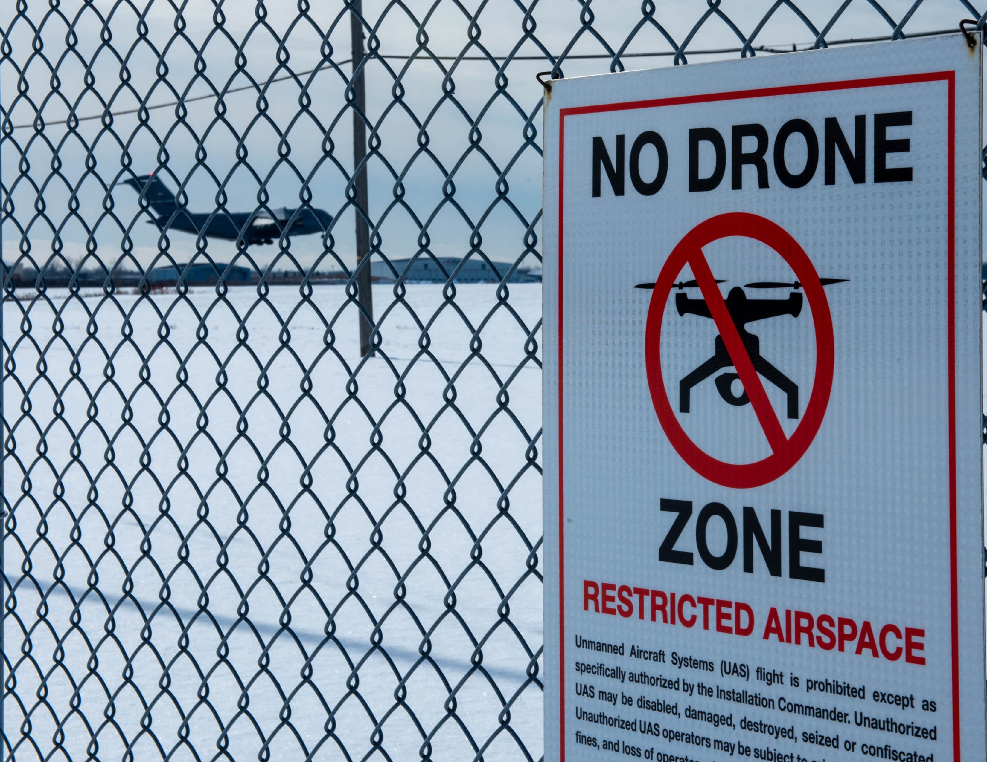 A C-17 Globemaster comes in for a landing at the Niagara Falls Air Reserve Station in New York on Feb. 10, 2021. A "No Drone Zone" is seen on the perimeter fence of the base.