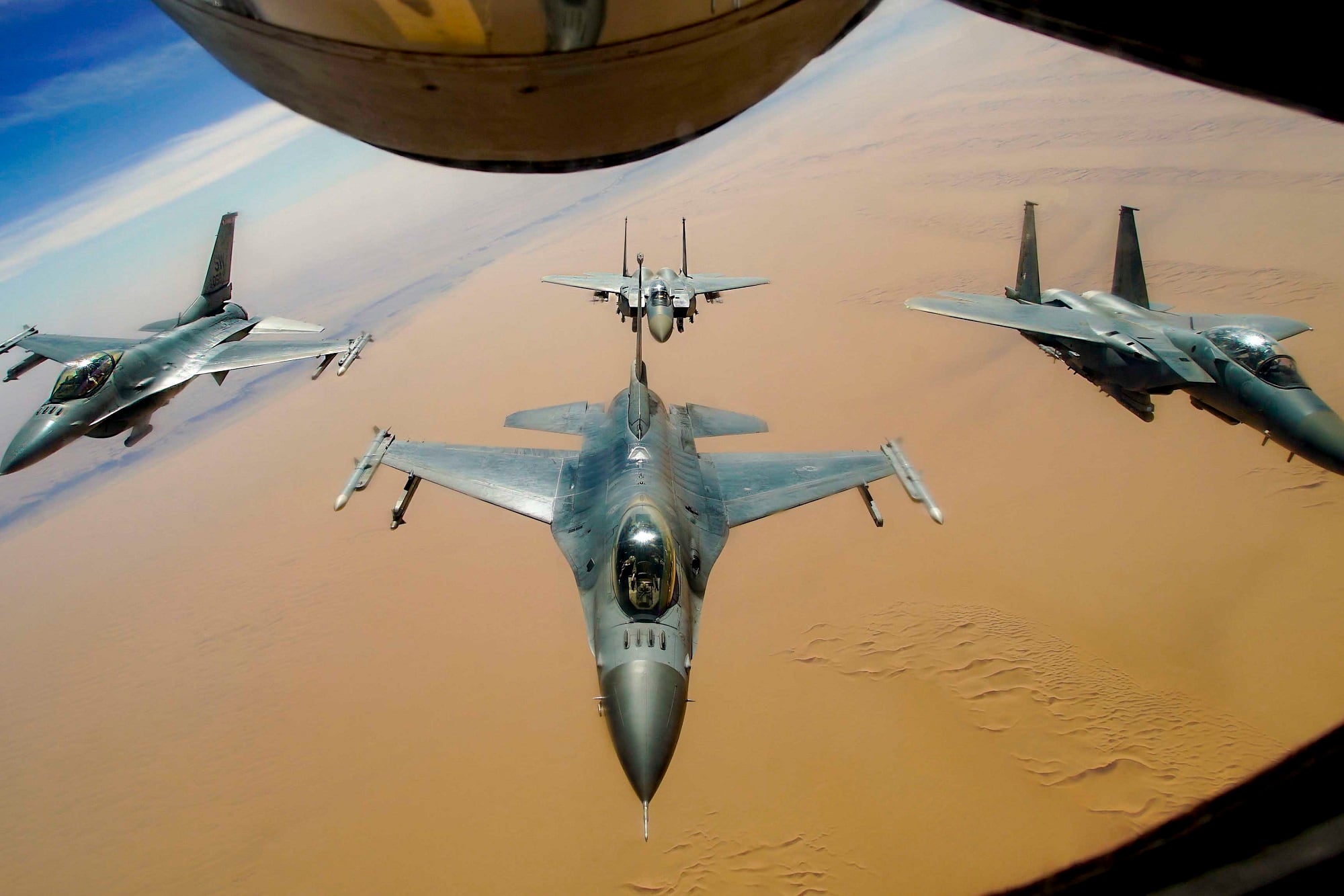 Two U.S. Air Force F-16 Fighting Falcons fly in formation with two Royal Saudi Air Force F-15E Strike Eagles after receiving fuel from a KC-135R Stratotanker during a routine exercise over Southwest Asia, Dec. 15, 2020.