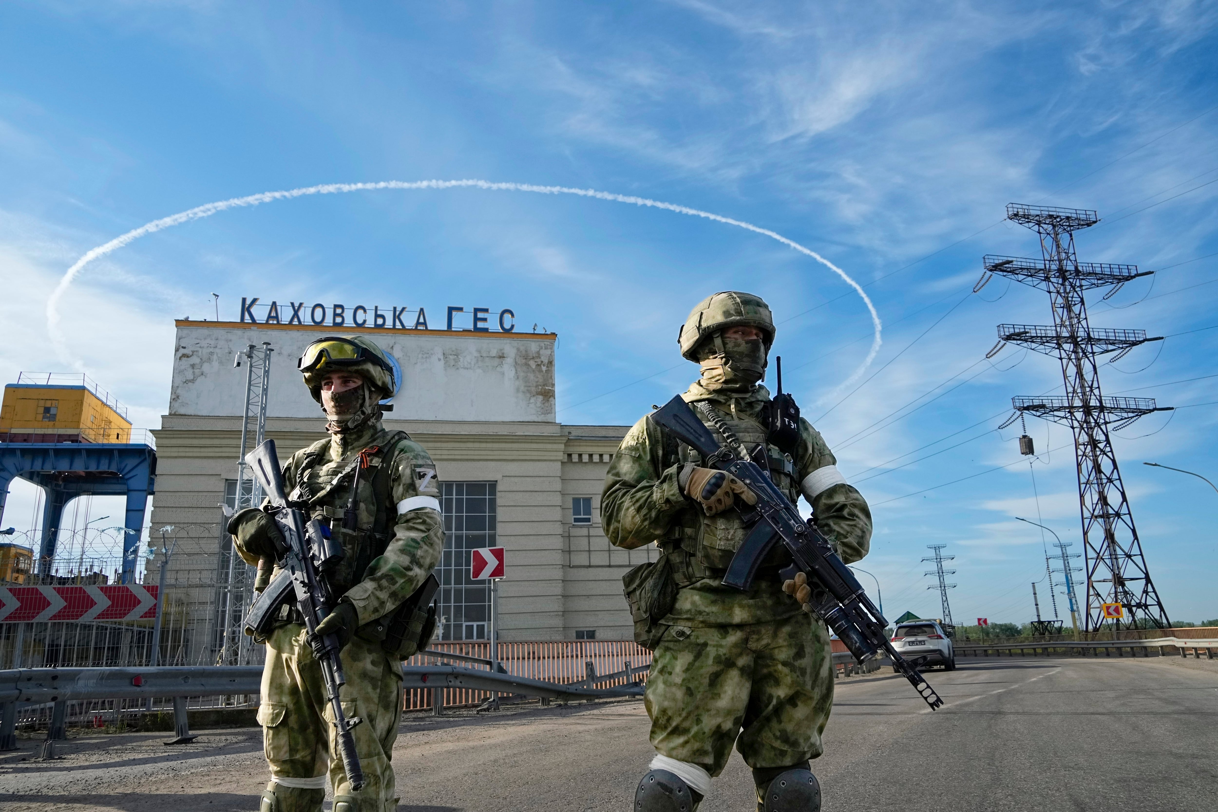 Russian troops guard an entrance of the Kakhovka Hydroelectric Station, a run-of-river power plant on the Dnieper River in the Kherson region, south Ukraine, Friday, May 20, 2022.