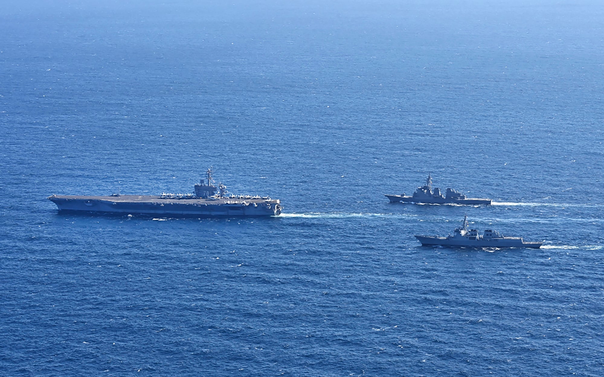 In this photo provided by South Korea's Joint Chiefs of Staff, the aircraft carrier USS Carl Vinson, left, sails with South Korean Navy's Aegis destroyer King Sejong the Great and Japan's Maritime Self-Defense Force Aegis destroyer Kongou in the international waters of the southern coast of Korean peninsular during a recent joint drill in 2024.