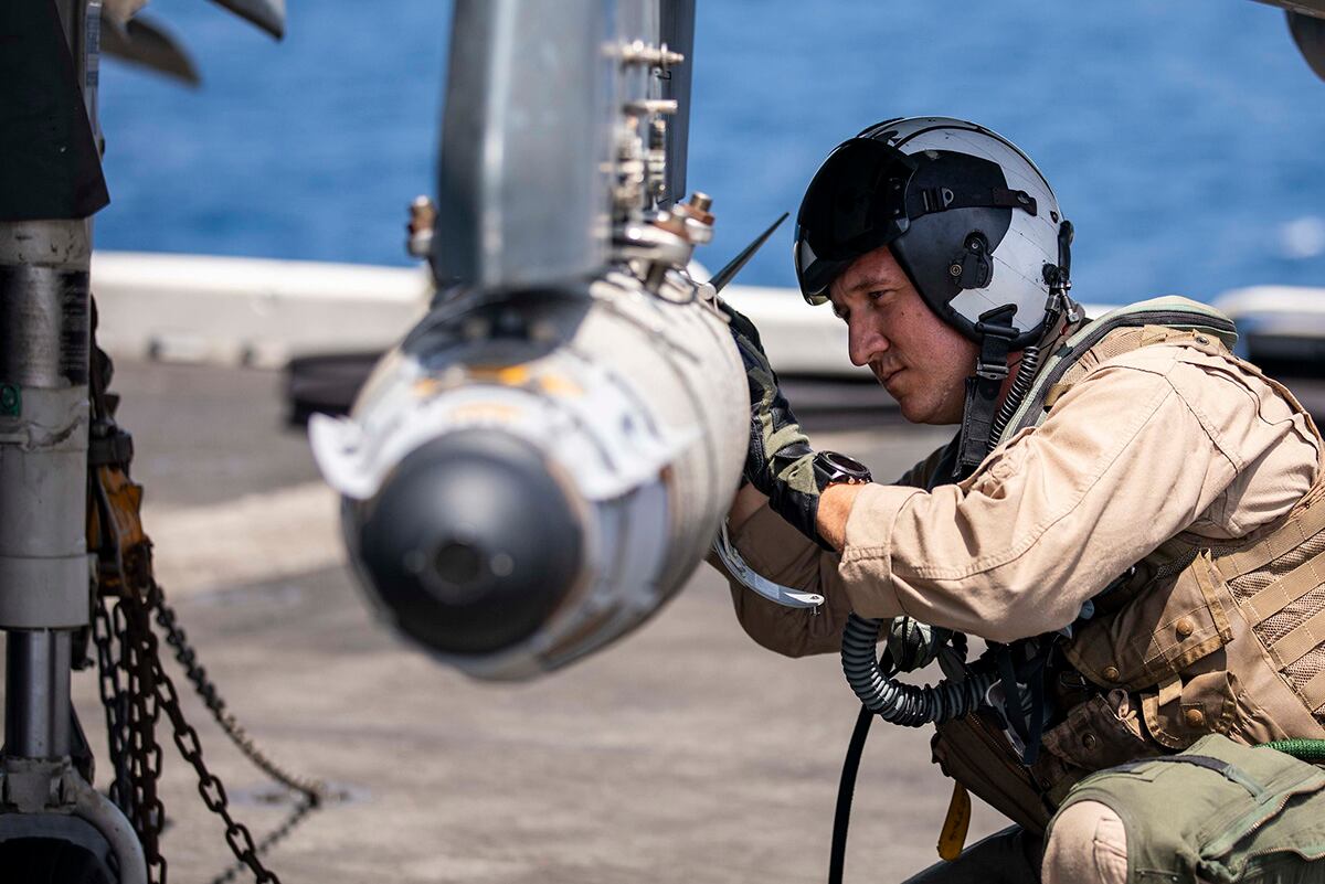 AV-8HB Harrier pilot Maj. Joseph Swindell inspects a GBU-54 joint direct attack munition during pre-flight checks May 20, 2019, on the flight deck of the Wasp-class amphibious assault ship USS Kearsarge (LHD 3) in the Arabian Sea.